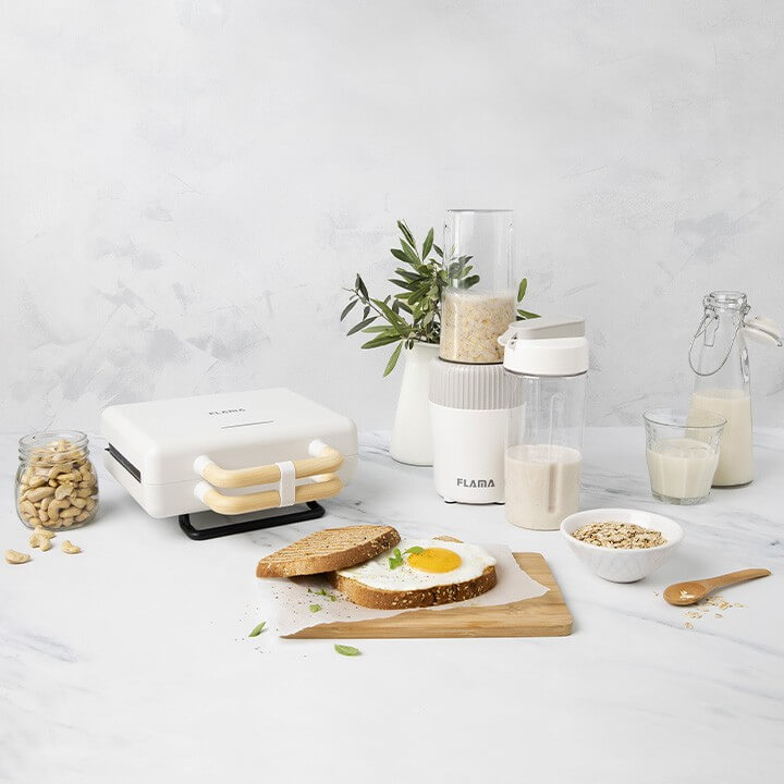 Conjunto de cozinha com uma sanduicheira e uma liquidificadora acompanhada de tostas com ovo, granola e cajus com cores vibrantes.