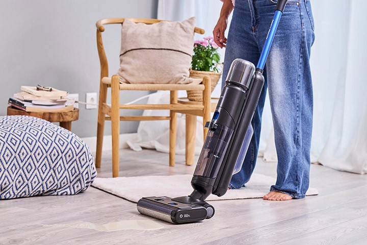 Homem a aspirar sala com um aspirador vertical sem fios Flama