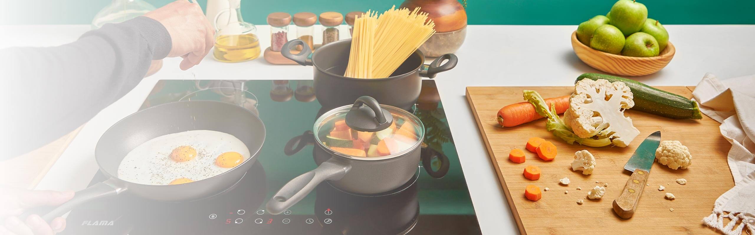 Panela de presso, wok, frigideira antiaderente e trem de cozinha sobre a bancada bancada