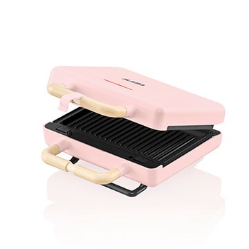 Torradeira cor de rosa para um toque mais feminino e com placas substituíveis para outras refeições.